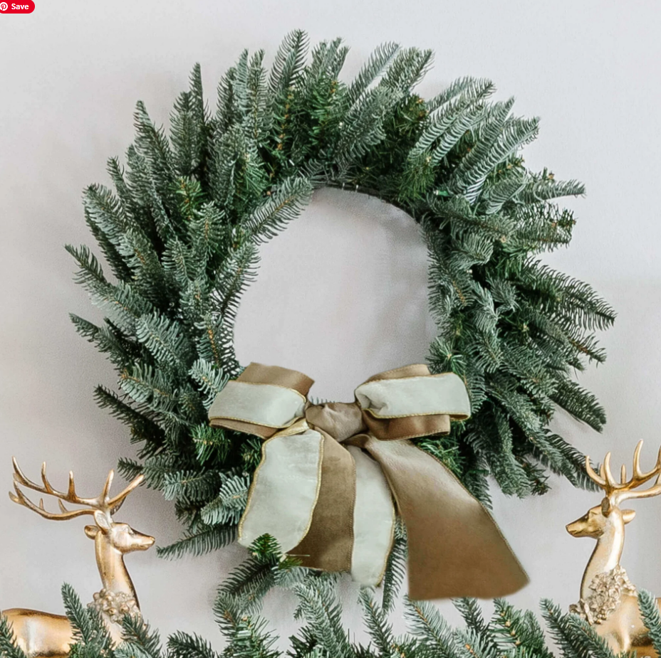 wreath with gold and cream ribbon in between two gold reindeer