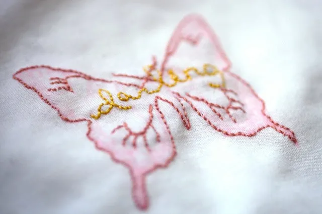 Butterflies like this pink one are a popular choice for embroidering on DIY baby onesies