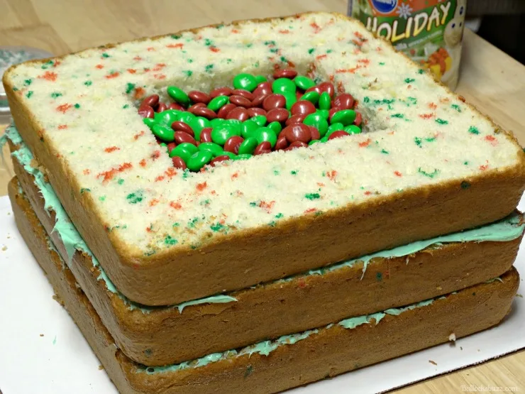 fill the holes in the middle of the Holiday Present Pinata Cake to the top with M&MS
