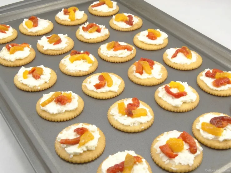 Roasted Pepper Cheese Bites and Holiday Party Planning Tips put crackers on baking sheet top with peppers