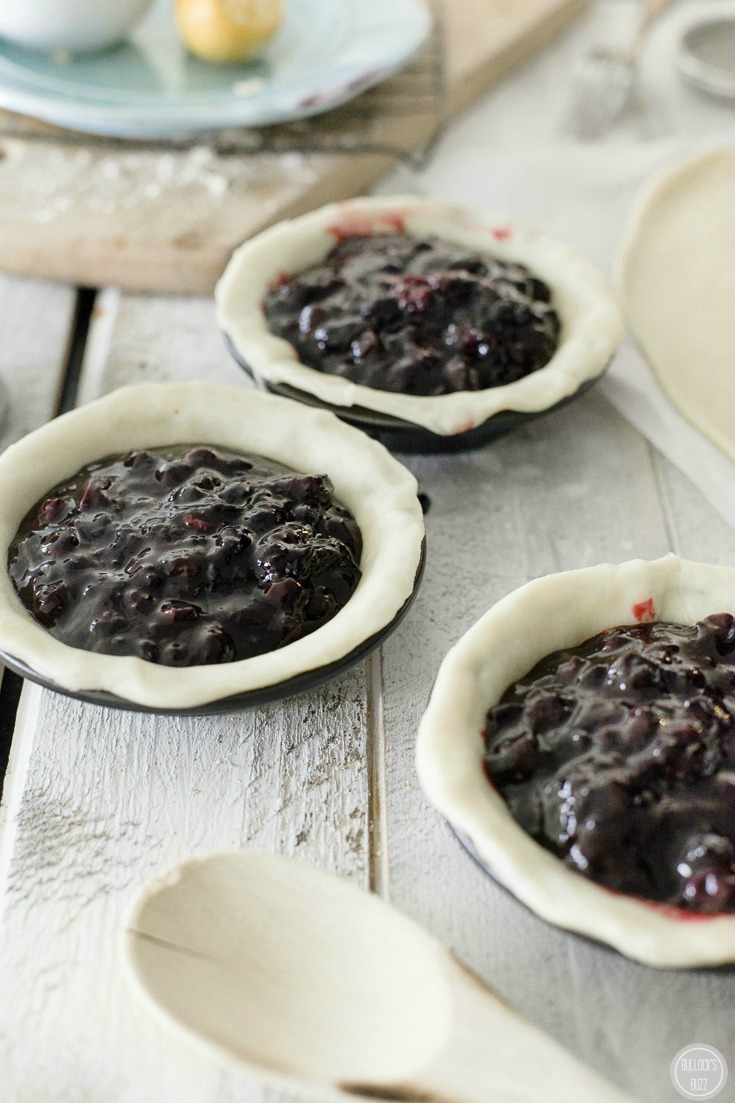mini blueberry pies add filling to pie bottoms
