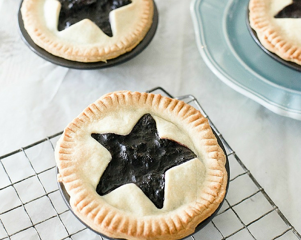 close up of mini blueberry pies with star cutouts