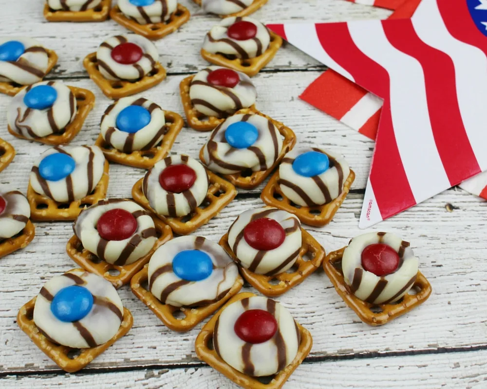 The sweet taste of chocolate combined with the salty taste of pretzels just can't be beat! Add in patriotic colors and these Patriotic Pretzel Hugs become perfect for your 4th of July celebration!