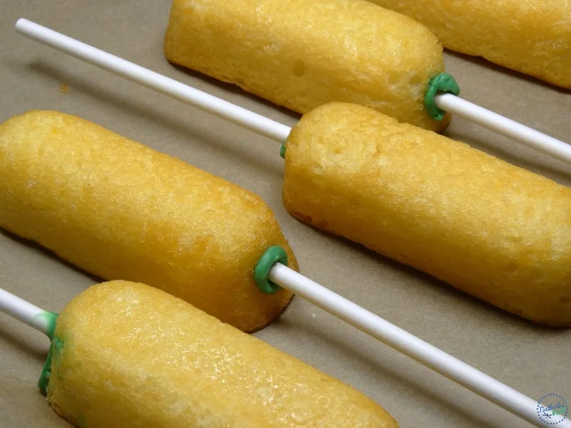 Close up of the lollipop sticks inserted in Twinkies before dipping