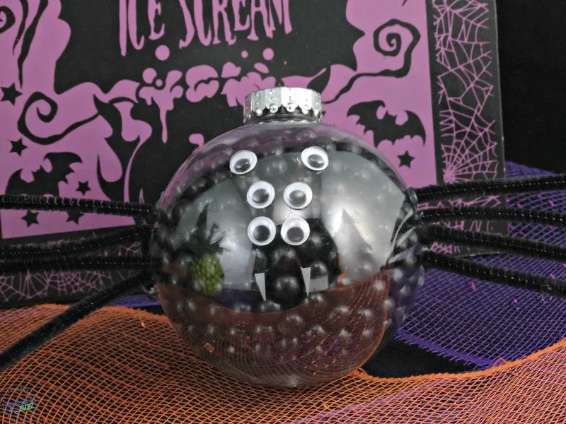 Ornament filled with black candies and decorated to look like a spider