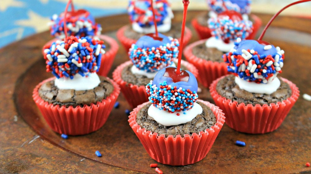 Made-from-scratch, rich, chocolatey brownie bites are topped with a chocolate covered cherry dipped in red, white and blue jimmies and nonpareils in this Patriotic Brownie Bombs recipe for summer celebrations!