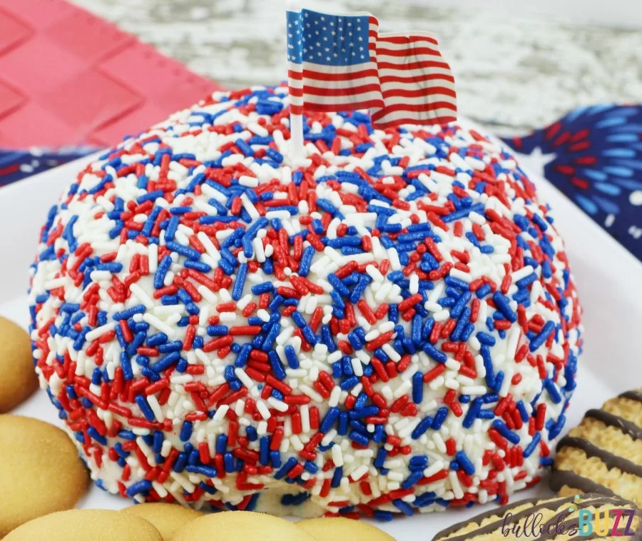 Colorful Funfetti cake mix is shaped into a ball, dipped in red, white and blue jimmies, then served as a dip in this deliciously sweet Patriotic Funfetti Cake Cheese Ball.