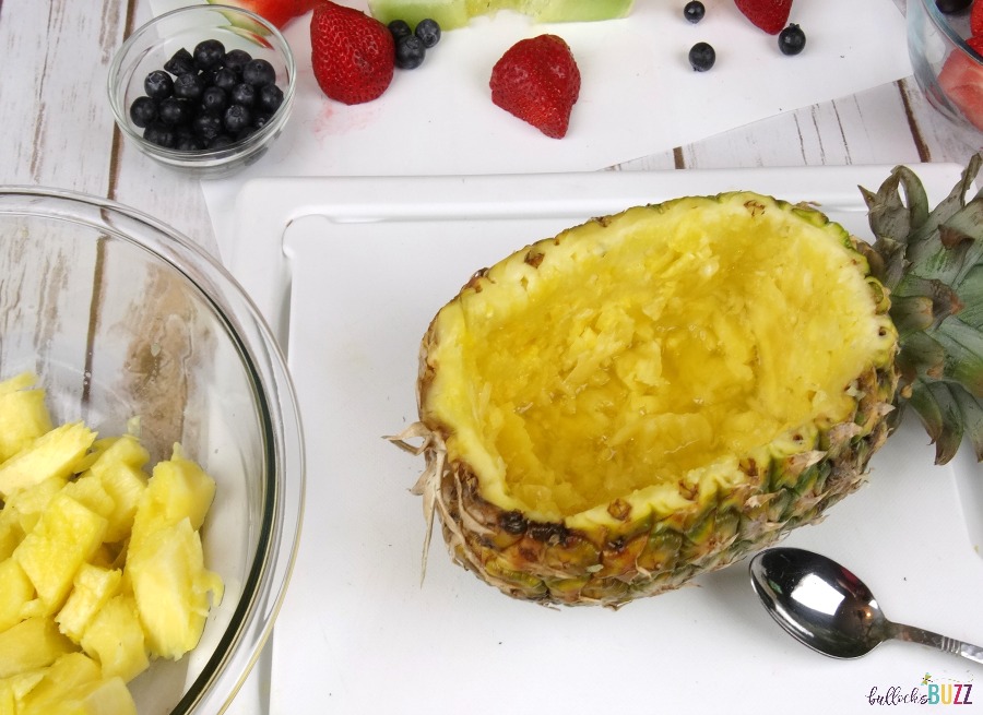 Pineapple Boat Fruit Salad pour out juice, scrape sides clean with spoon