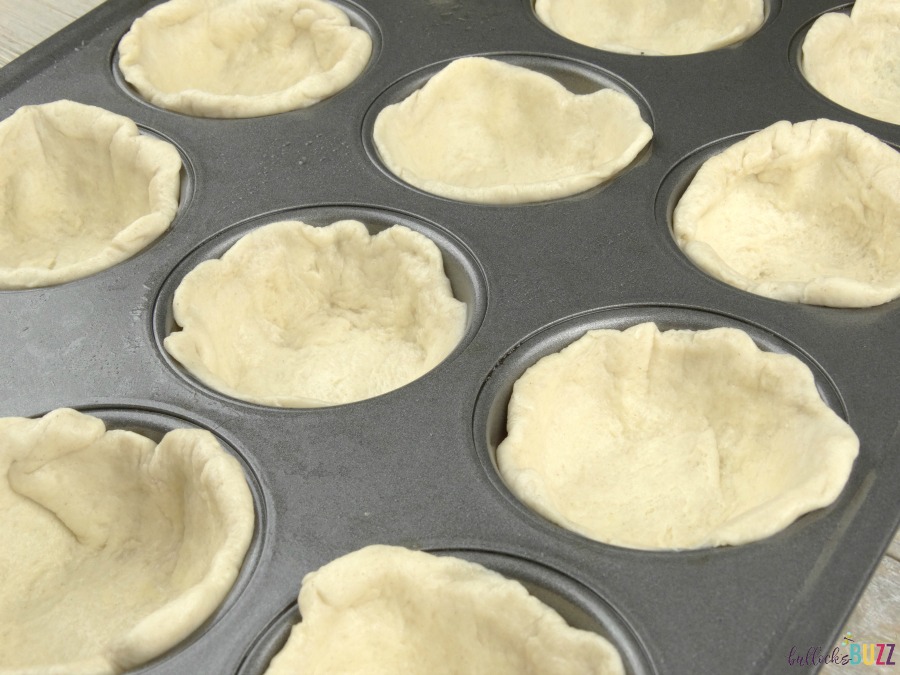 Sausage, Egg and Herbed Cheese Breakfast Muffins use half a biscuit to form a cup shape in the muffin tin