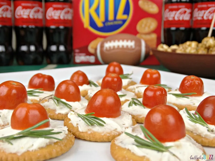 Top each cracker with the herbed cream cheese and a slice of tomato and rosemary to complete this game day recipe for Rosemary, Tomato & Herbed Cream Cheese Bites