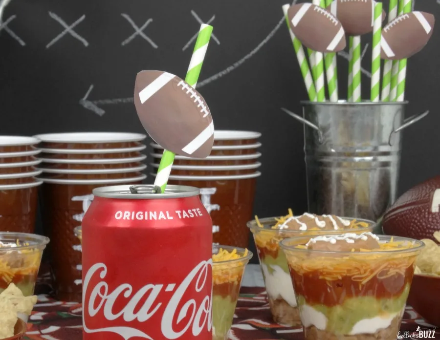 printable football straw topper on a straw in a can of Coke