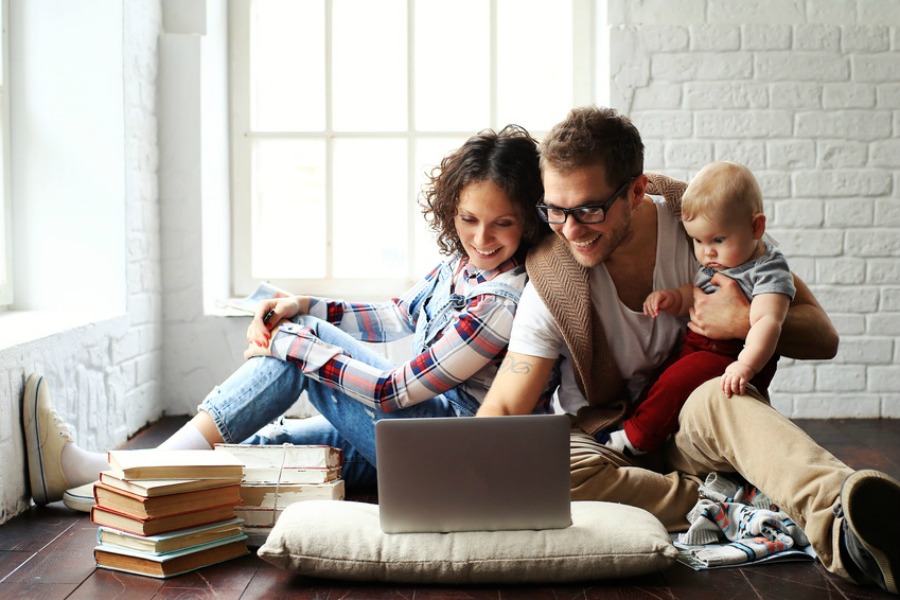 mother father and baby on computer together