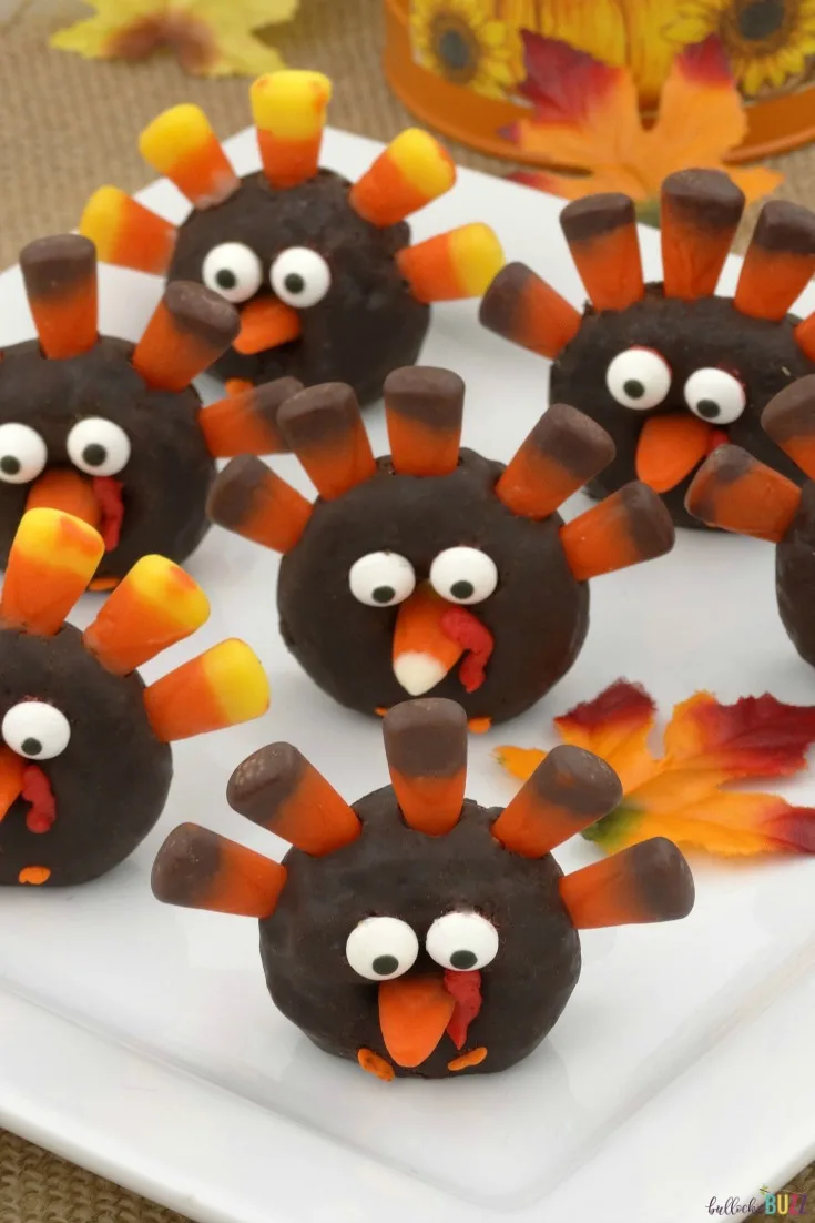 Close up of Mini Turkey Donuts with candy corn feathers on a plate.