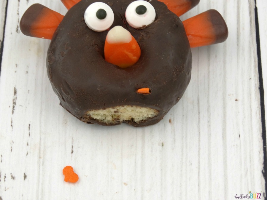 Using pumpkin shaped sprinkles to make the feet on the donut turkeys.