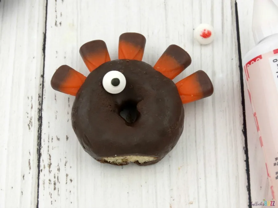 Use a dab of icing as glue to attach the eyes to the donut turkeys.