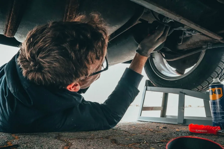 man working under car on DIY car maintenance