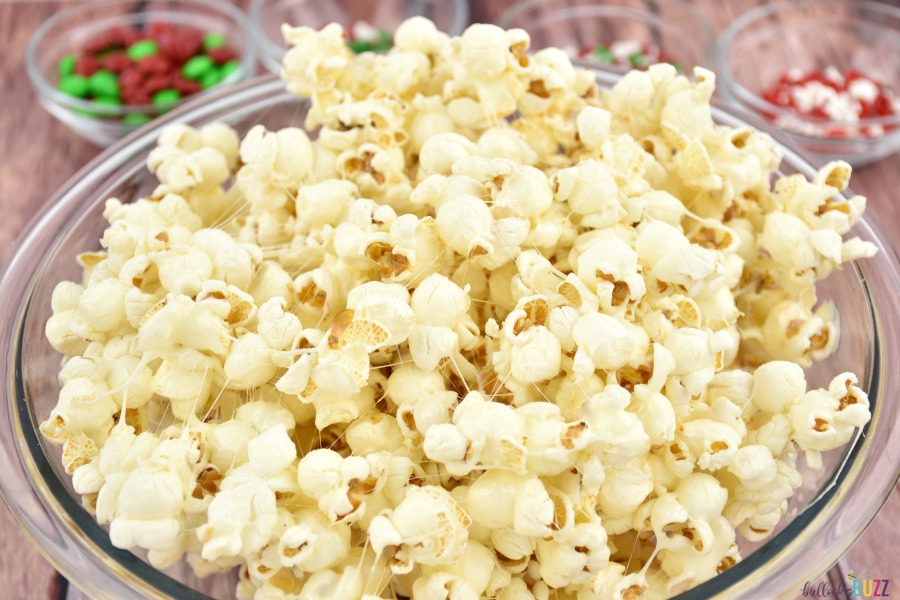 A bowl of popcorn coated with melted marshmallow in the first part of making holiday popcorn 