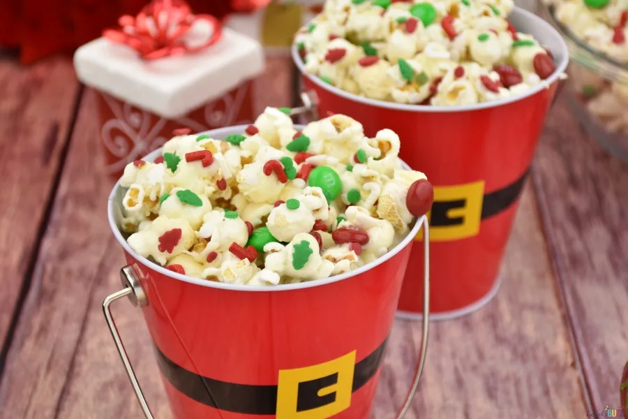 Holiday popcorn with red and green sprinkles and M&Ms served in Santa pails