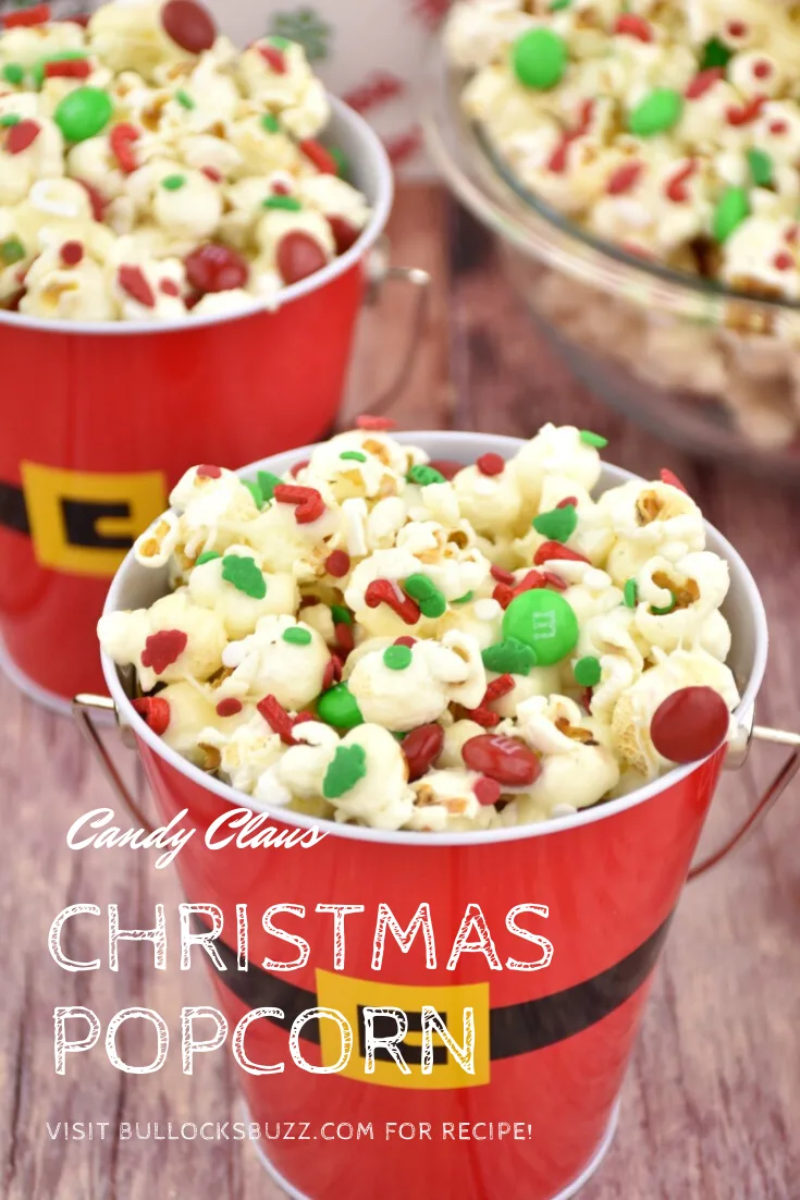 A Santa pail filled with marshmallow-coated popcorn that has been sprinkled with red and green M&Ms and Christmas-themed sprinkles