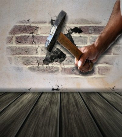 man with a sledge hammer in front of a wall