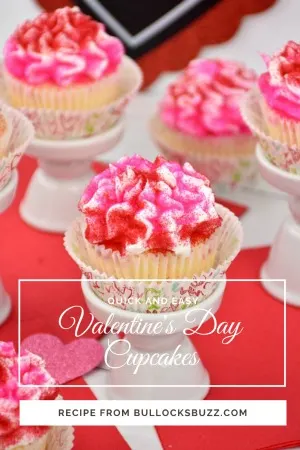 Overhead shot of pretty cupcakes for Valentine's Day with white frosting and red and pink sugar sprinkles.