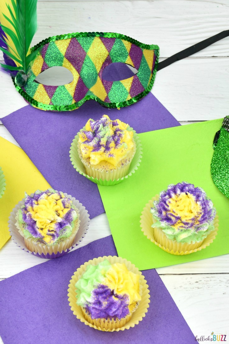 Mardi Gras vanilla cupcakes are crowned with a fluffy cloud of vanilla buttercream frosting, then dusted with green, purple, and gold sprinkles. 