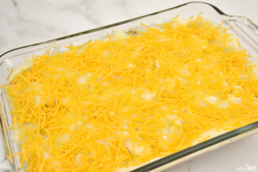 shepherd's pie in dish topped with a layer of shredded cheese