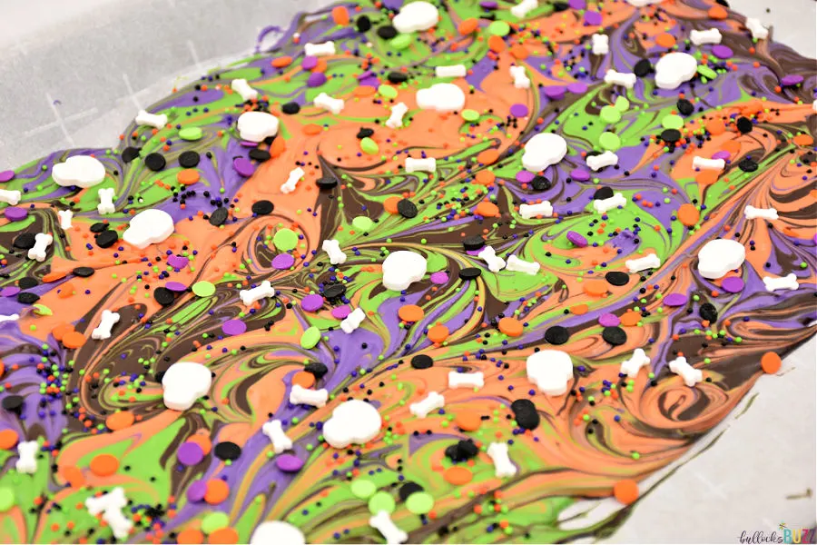 add sprinkles to swirled Halloween candy bark