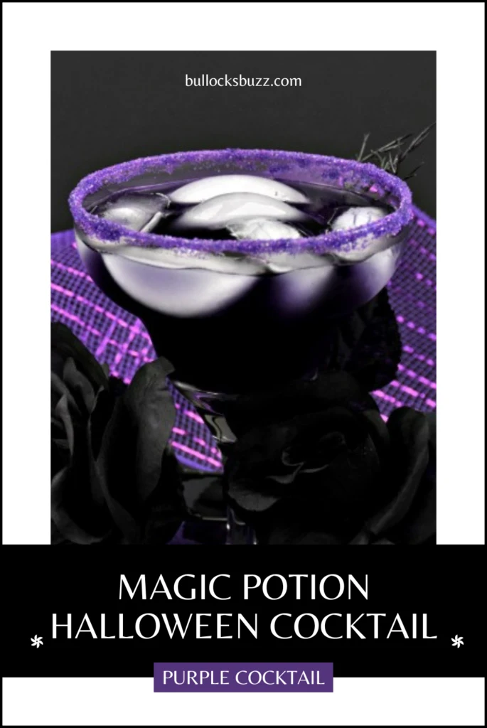 Close up image of the purple Halloween cocktail with ice in a martini glass that has purple sugar around the rim.