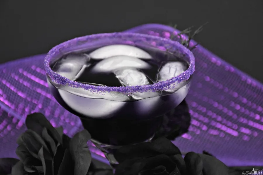 purple cocktail with purple sanding sugar on rim