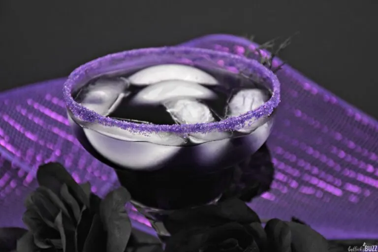 close up of the Magic Potion easy purple Halloween cocktail recipe in a glass on a purple background