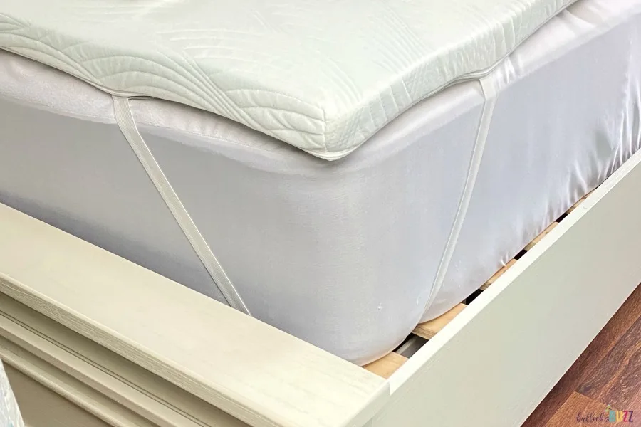 corner straps holding mattress topper on bed