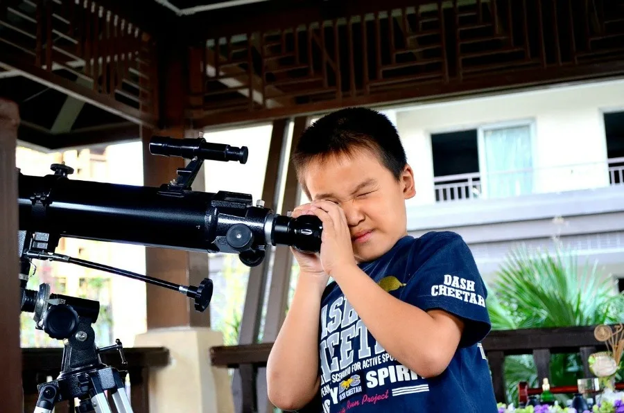 boy looking through telescope