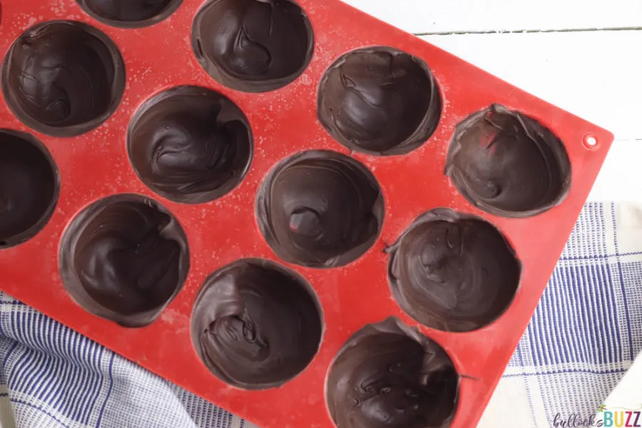 evenly fill molds with meted chocolate