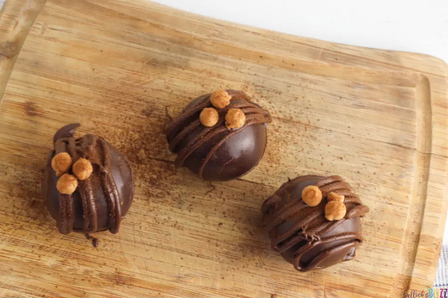 decorate the finished Caramel Mocha Coffee Bombs with a drizzle of chocolate, a caramel bit and sprinkle of espresso powder