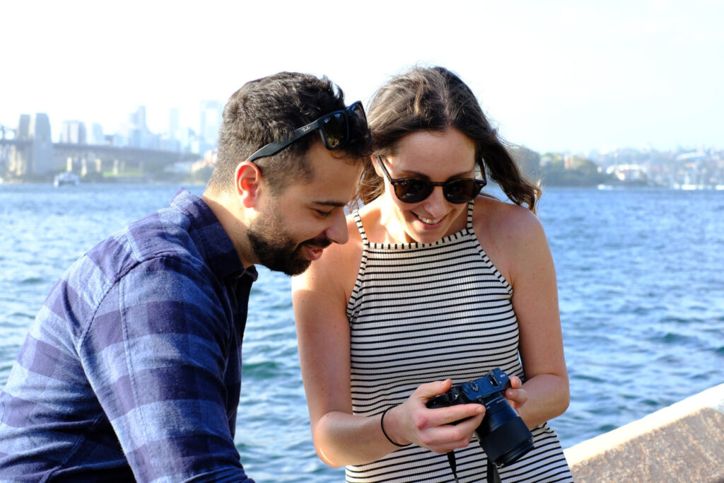  couple by the water looking at images on camera