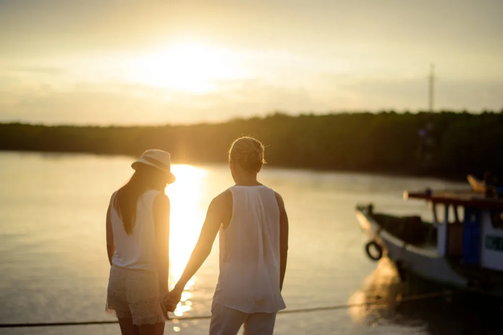 another relationship goal is to talk through disagreements like this couple is while they stand by the water at sunset