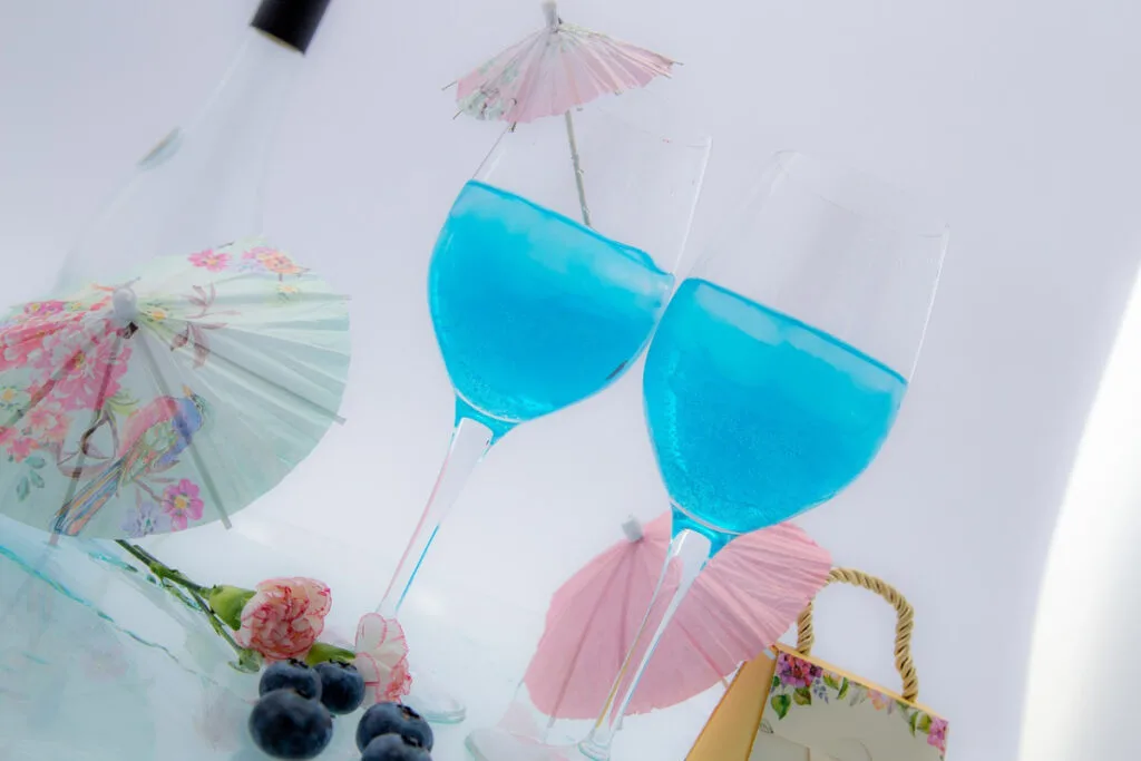 two blue cocktails on a tray