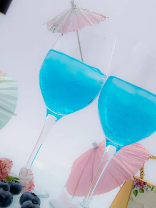 two blue cocktails on a tray
