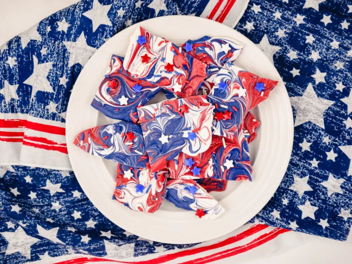 red, white and blue candy bark on a white plate