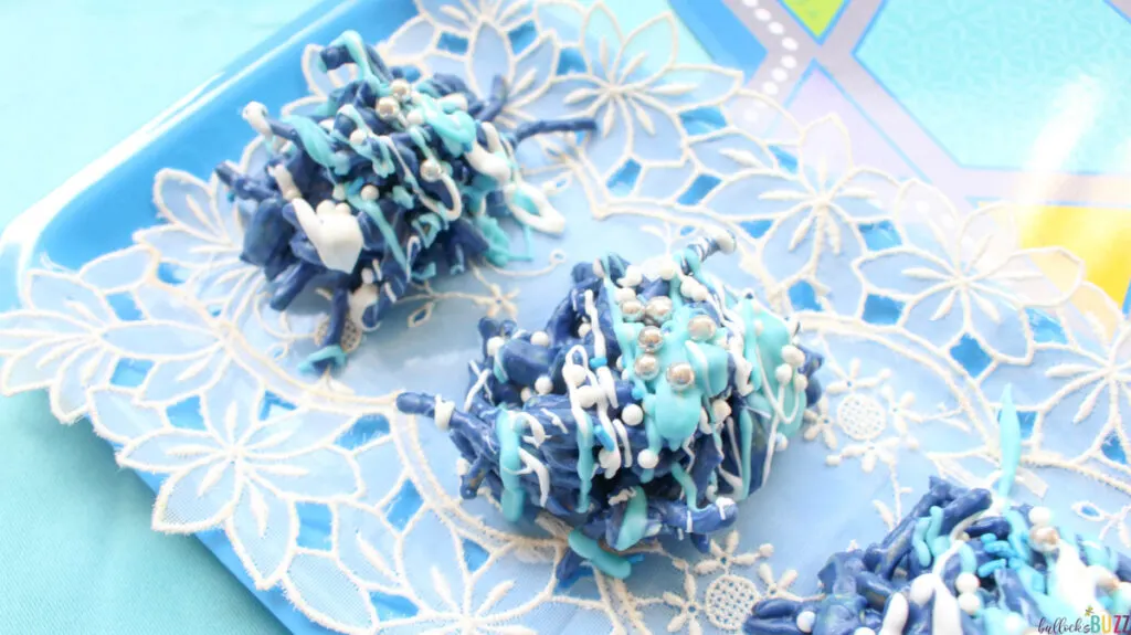 Close up of blue and white, chocolate covered Hanukkah Haystacks on tray
