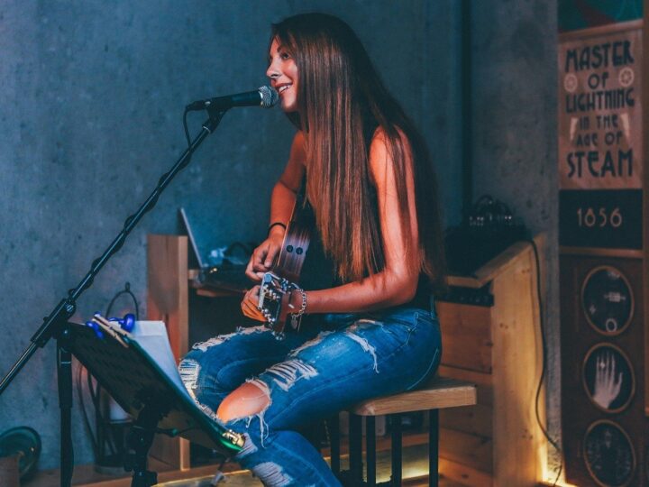 woman singing while playing guitar