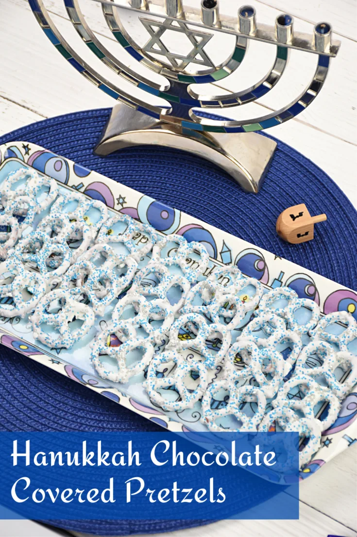 White chocolate-covered pretzels decorated with silver and blue sprinkles are laid out on a Hanukkah tray