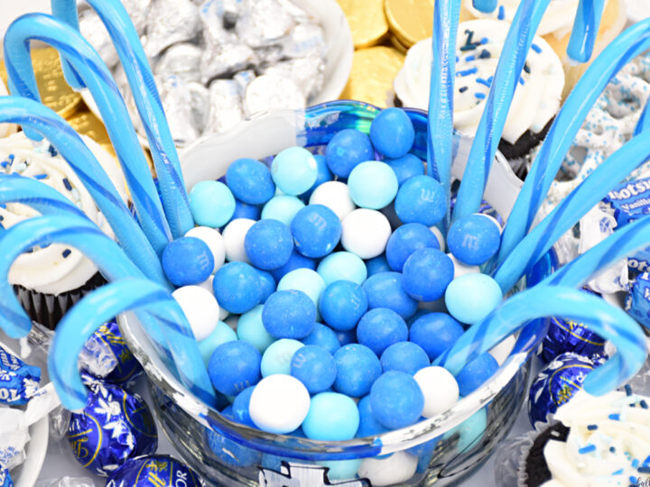 bowl of white and blue candies surrounded by blue candy canes on candy board