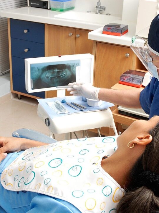 patient waiting in dentist's chair to have one of the types of cosmetic dental procedures
