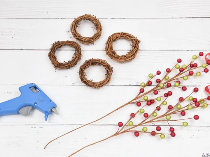 berry picks, wreath forms and hot glue gun are the supplies needed to make these DIY Napkin Rings for Christmas