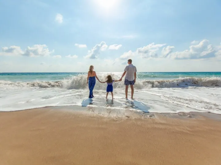 these financial tips for families can help you create a lifestyle where you can takes trips to the beach like this family walking on the beach together