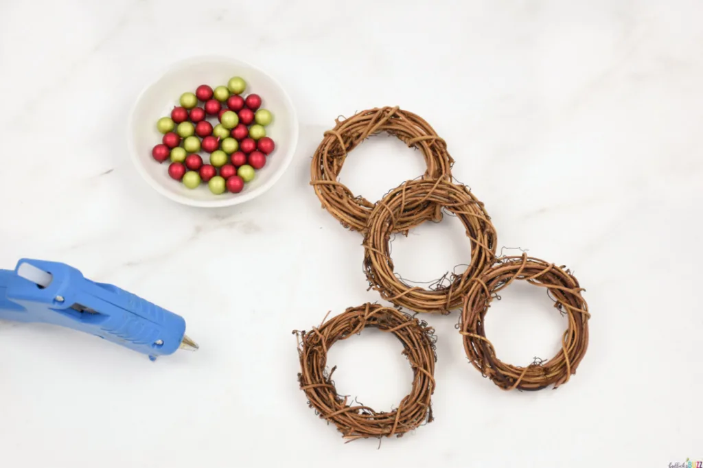 berries in a bowl next to wreath forms and hot glue gun