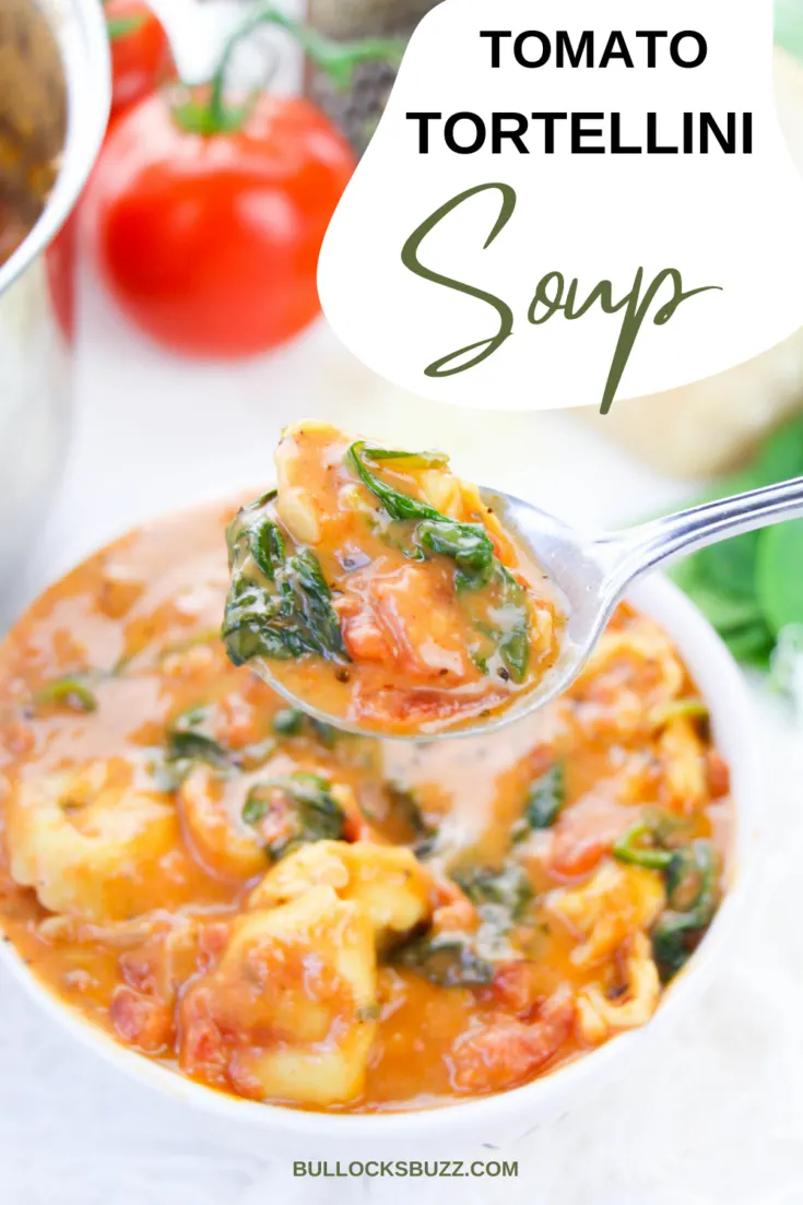 a spoonful of tomato tortellini soup above a white bowl