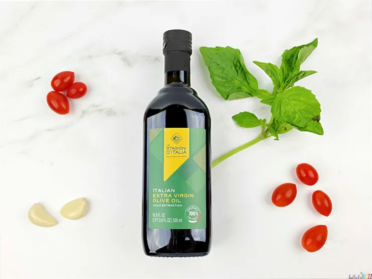 bottle of olive oil with tomatoes and garlic